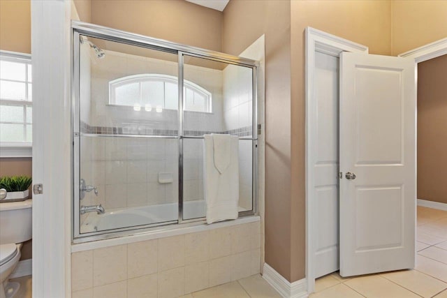 bathroom with toilet, tile patterned flooring, and enclosed tub / shower combo