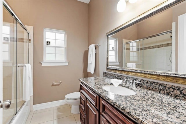 full bathroom featuring toilet, vanity, tile patterned flooring, and shower / bath combination with glass door