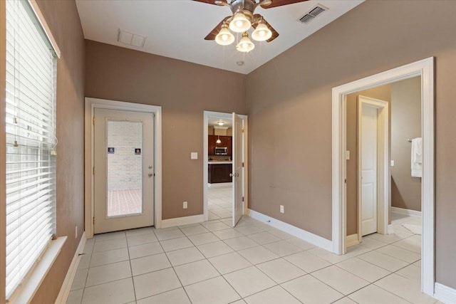 empty room with ceiling fan and light tile patterned flooring