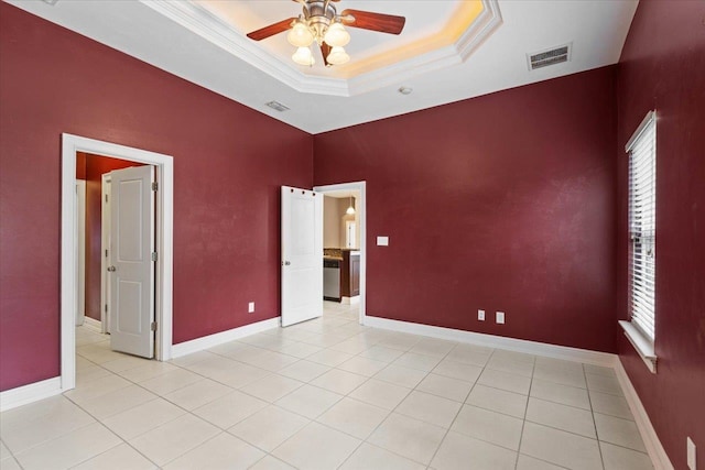 unfurnished bedroom with crown molding, ceiling fan, a raised ceiling, and light tile patterned floors