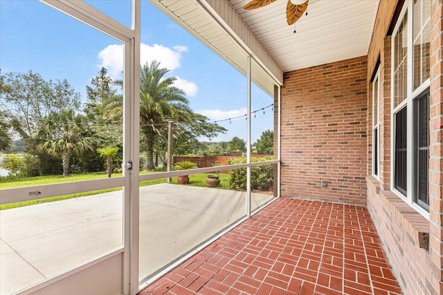 unfurnished sunroom featuring ceiling fan