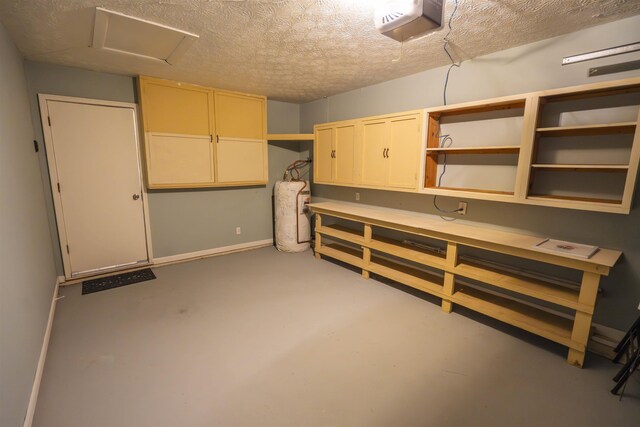 1553 Goodwood Dr, Tallahassee, FL 32308 - basement with gas water heater, a textured ceiling, a workshop area, and baseboards
