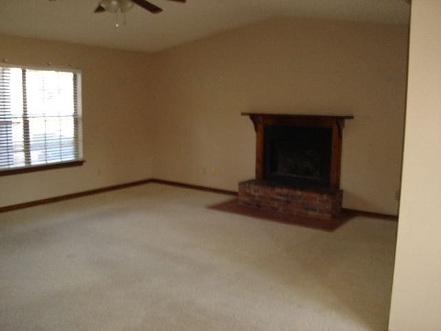 unfurnished living room featuring carpet flooring, ceiling fan, and a fireplace