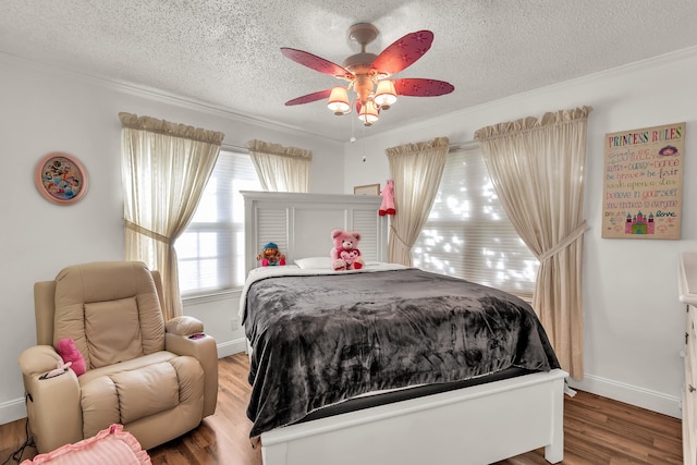 bedroom featuring hardwood / wood-style floors, crown molding, a textured ceiling, and ceiling fan