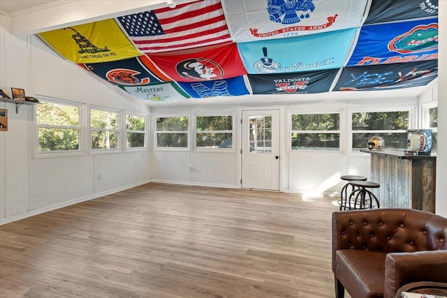 living area with lofted ceiling, plenty of natural light, and light wood-type flooring