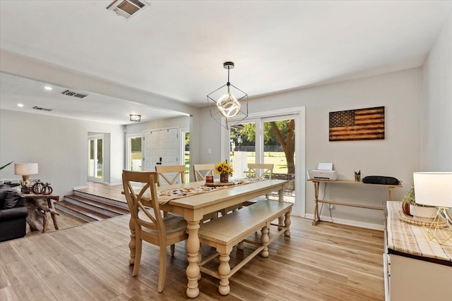 dining area featuring light hardwood / wood-style flooring and a chandelier