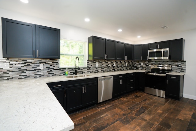 3313 N Ridge Rd, Tallahassee, FL 32305 - kitchen with stainless steel appliances, a sink, decorative backsplash, recessed lighting, and light stone countertops