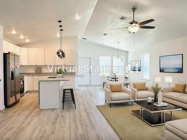 living room featuring vaulted ceiling, light wood finished floors, baseboards, visible vents, and a ceiling fan