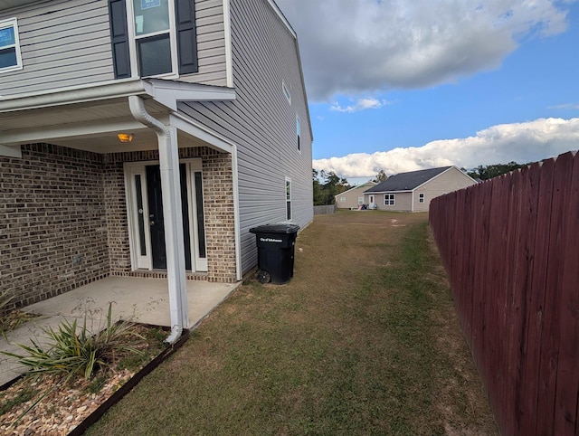 view of home's exterior with a lawn and a patio