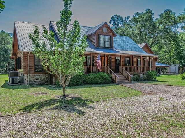 883 Hunters Trce, Crawfordville, FL 32327 - log cabin featuring covered porch, log exterior, a metal roof, a front yard, and an outbuilding