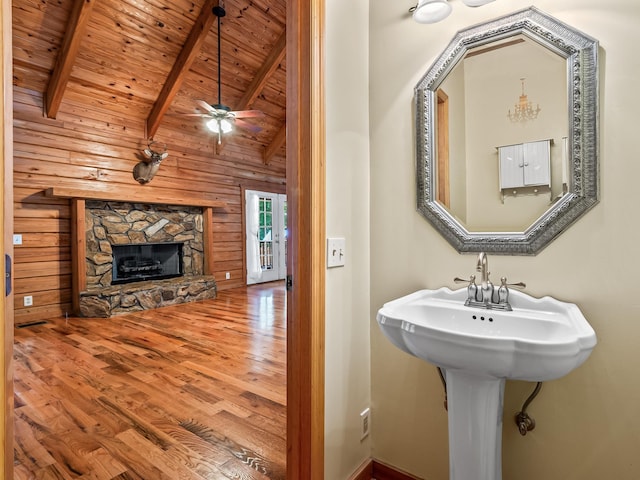 883 Hunters Trce, Crawfordville, FL 32327 - bathroom featuring wooden ceiling, wooden walls, wood finished floors, a fireplace, and a ceiling fan