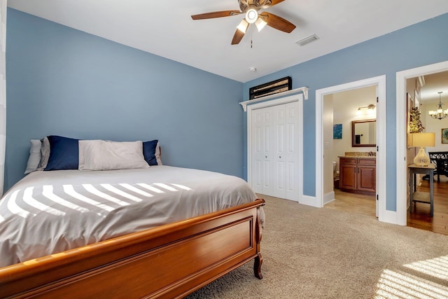 bedroom featuring visible vents, baseboards, ensuite bath, a closet, and light colored carpet