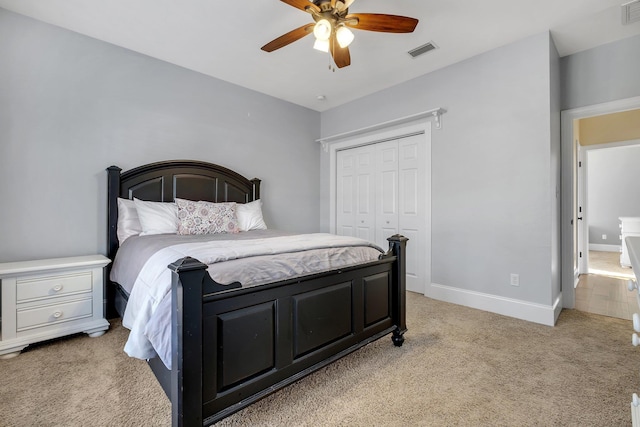 bedroom featuring visible vents, light carpet, baseboards, and a closet