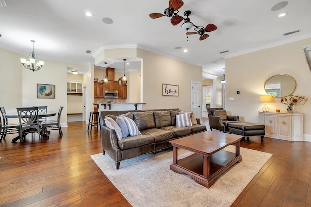 living room featuring visible vents, recessed lighting, dark wood-style flooring, crown molding, and ceiling fan with notable chandelier