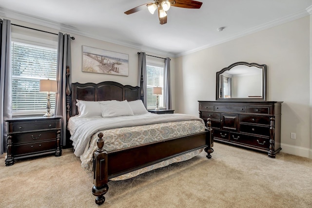 carpeted bedroom featuring baseboards, crown molding, and ceiling fan