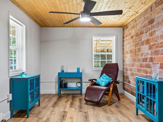 living area with a healthy amount of sunlight, light hardwood / wood-style floors, and wooden ceiling