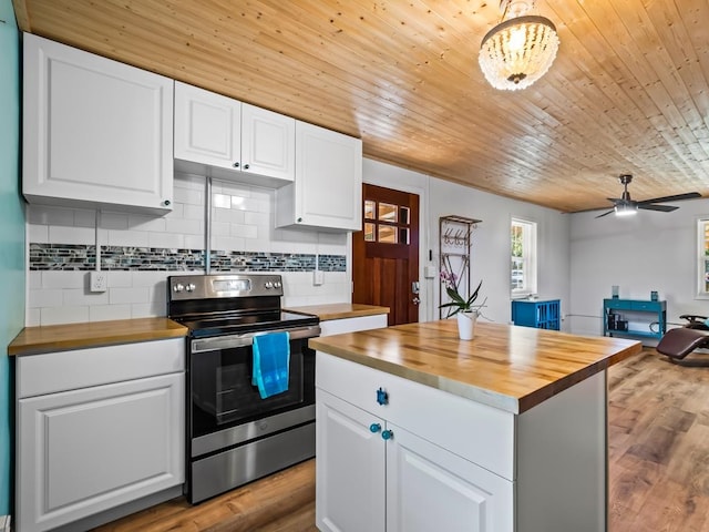 kitchen featuring butcher block countertops, white cabinets, and electric range