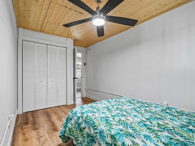 bedroom featuring wood-type flooring, a closet, ceiling fan, and wooden ceiling