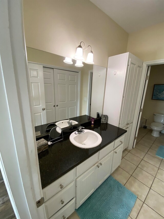 bathroom featuring tile patterned flooring, vanity, and toilet