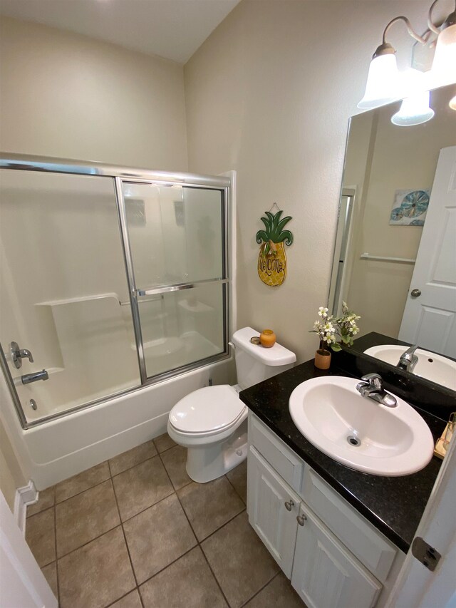 full bathroom with vanity, tile patterned floors, combined bath / shower with glass door, and toilet