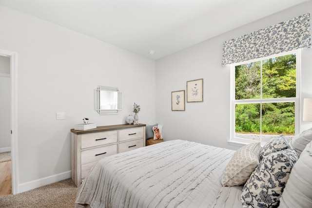 bedroom with light carpet and multiple windows