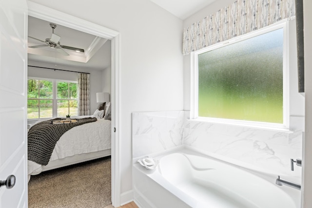 bathroom featuring a bath, ornamental molding, ceiling fan, and a healthy amount of sunlight