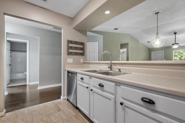 7326 Hollis St, Tallahassee, FL 32312 - kitchen with stainless steel dishwasher, light countertops, hanging light fixtures, white cabinets, and vaulted ceiling