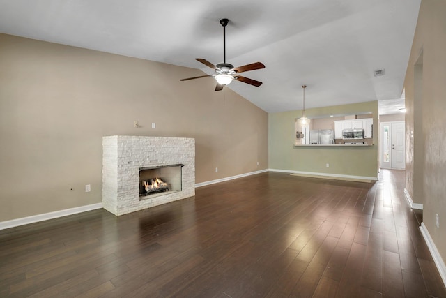 7326 Hollis St, Tallahassee, FL 32312 - unfurnished living room featuring ceiling fan, lofted ceiling, dark wood finished floors, and a stone fireplace