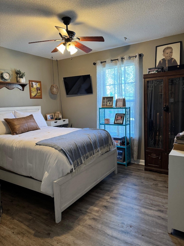 bedroom featuring ceiling fan, dark hardwood / wood-style floors, and a textured ceiling