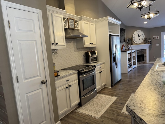 kitchen with light stone countertops, appliances with stainless steel finishes, decorative light fixtures, white cabinetry, and dark hardwood / wood-style floors