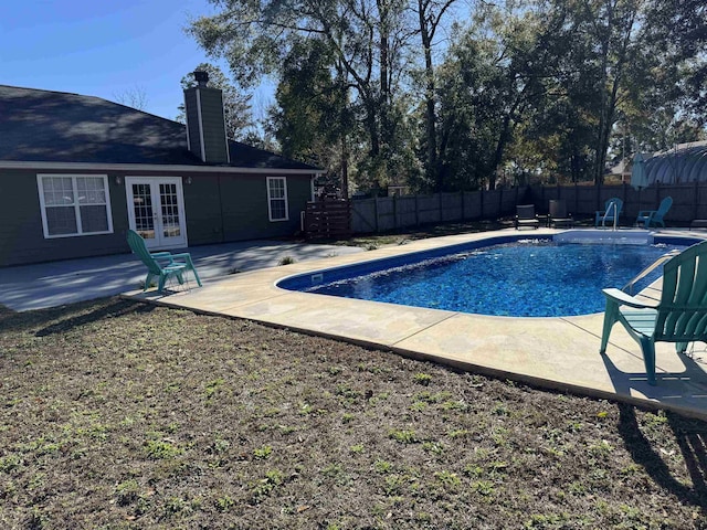 view of swimming pool featuring french doors and a patio area