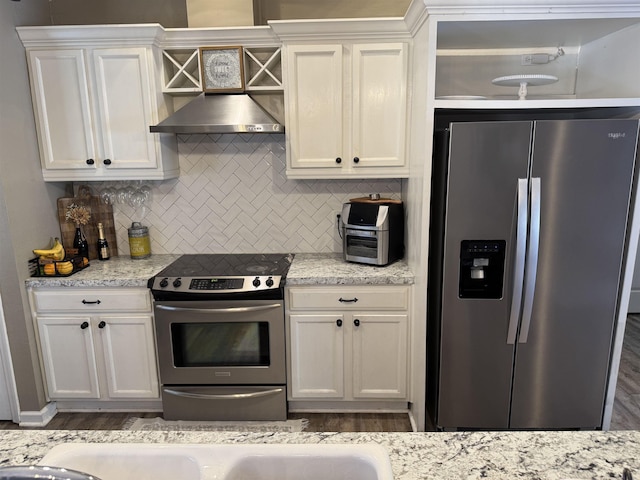 kitchen featuring appliances with stainless steel finishes, decorative backsplash, white cabinets, and light stone countertops