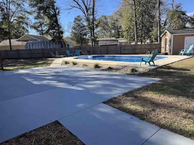 view of pool with a patio and a shed