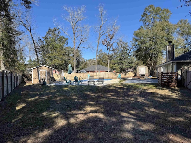 view of yard featuring a shed, a patio area, and a fenced in pool