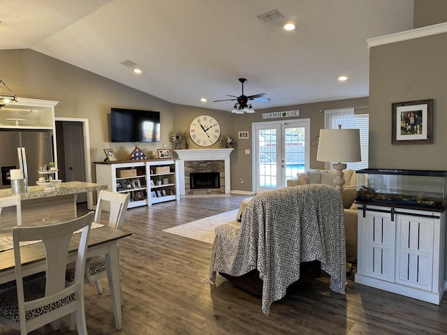 living room featuring dark hardwood / wood-style flooring, lofted ceiling, french doors, and a fireplace