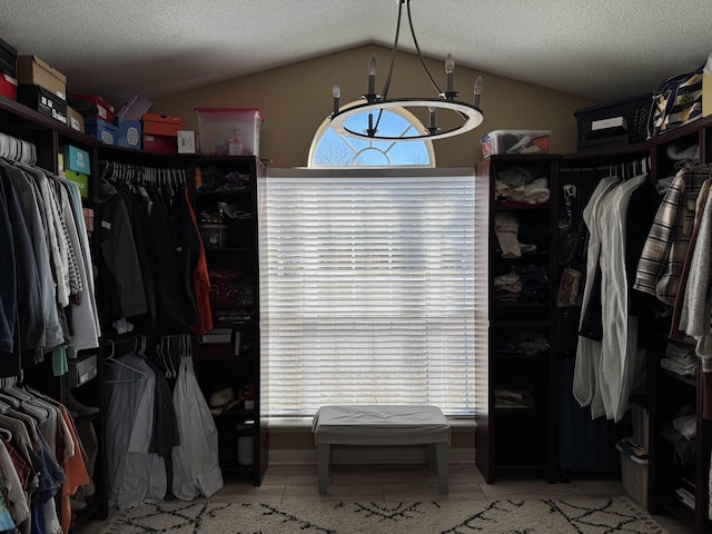 spacious closet featuring vaulted ceiling and light tile patterned flooring