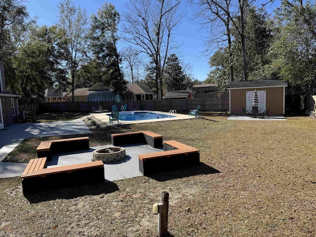 view of yard featuring a fenced in pool, a storage unit, a patio, and a fire pit