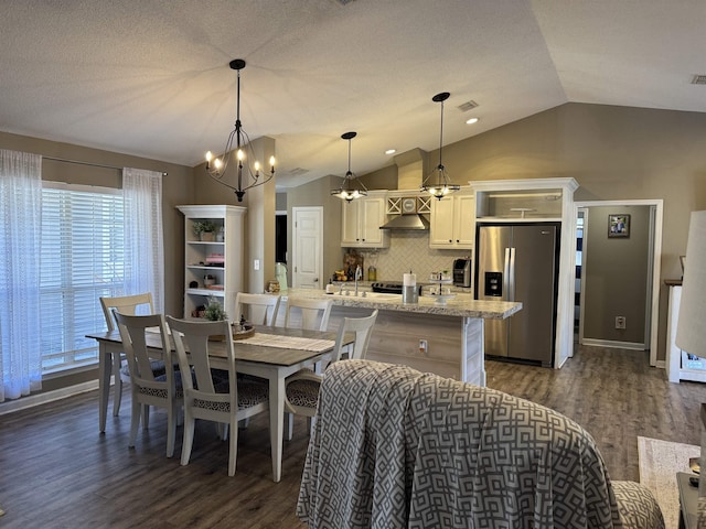 dining space featuring a textured ceiling, dark hardwood / wood-style flooring, and vaulted ceiling