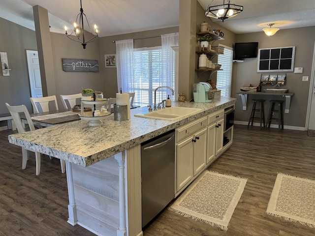 kitchen featuring decorative light fixtures, sink, stainless steel dishwasher, and a center island with sink