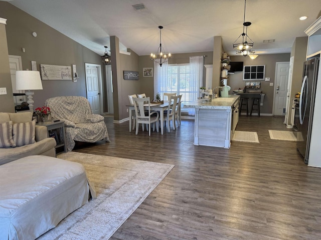 living room with vaulted ceiling, dark wood-type flooring, and a chandelier