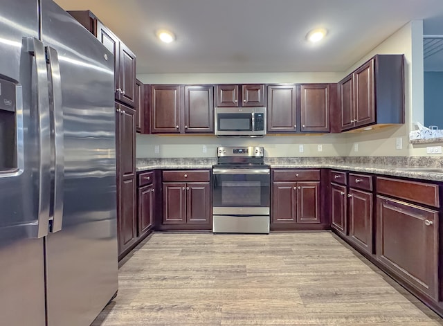 4641 Rivers Landing Way, Tallahassee, FL 32303 - kitchen with appliances with stainless steel finishes, dark brown cabinets, light wood-type flooring, and light countertops