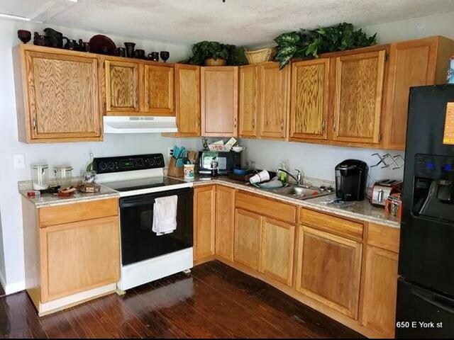 kitchen featuring dark hardwood / wood-style flooring, sink, black fridge with ice dispenser, and white range with electric cooktop