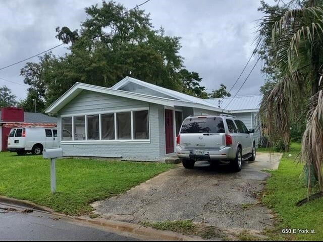 view of front of house featuring a front lawn and a sunroom