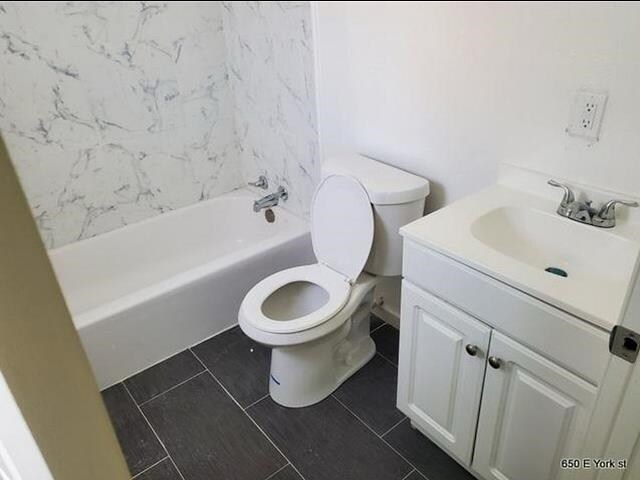 bathroom with tile patterned flooring, vanity, and toilet