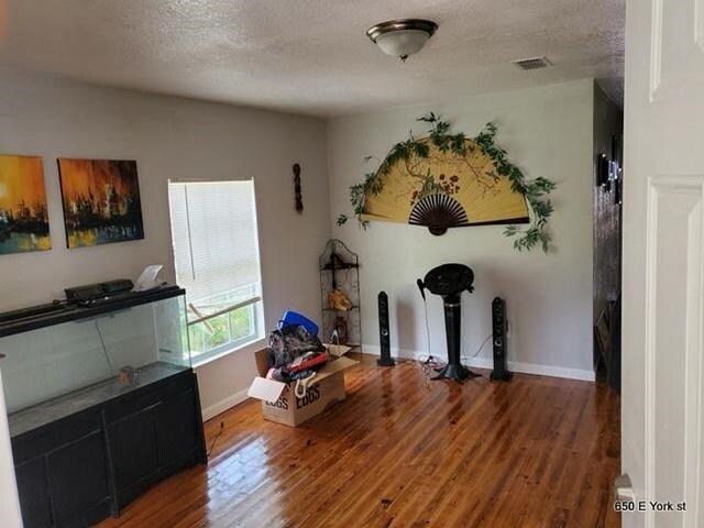 miscellaneous room featuring hardwood / wood-style floors and a textured ceiling