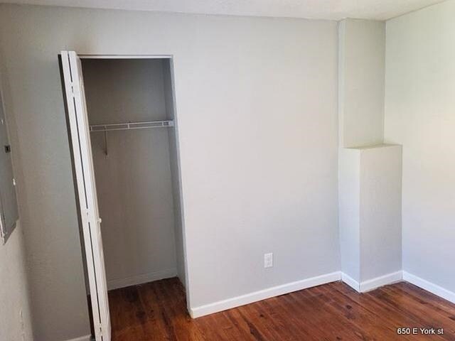 unfurnished bedroom featuring dark hardwood / wood-style floors and a closet