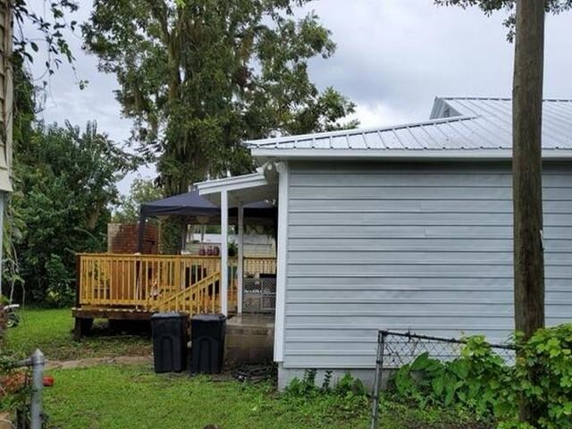 view of property exterior featuring a lawn and a wooden deck