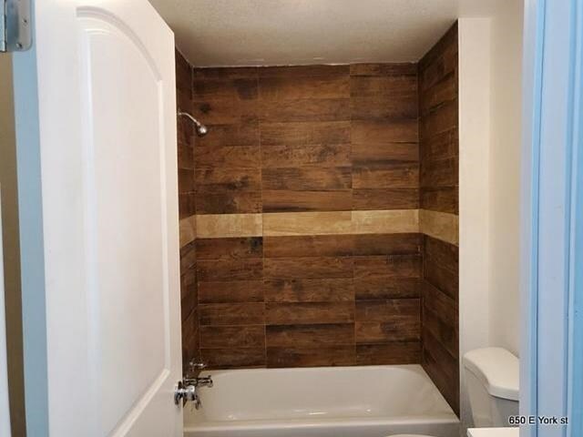 bathroom featuring toilet and shower / washtub combination