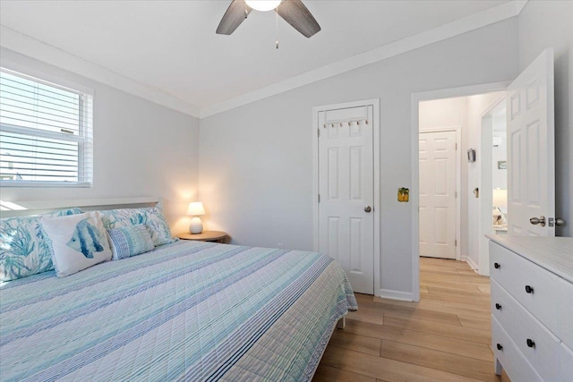 bedroom featuring ornamental molding, ceiling fan, and light wood-type flooring