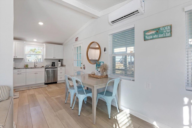 dining area featuring sink, an AC wall unit, lofted ceiling with beams, and light hardwood / wood-style floors